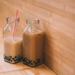 two clear glass jars with straws