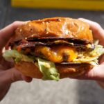 person holding cheese burger